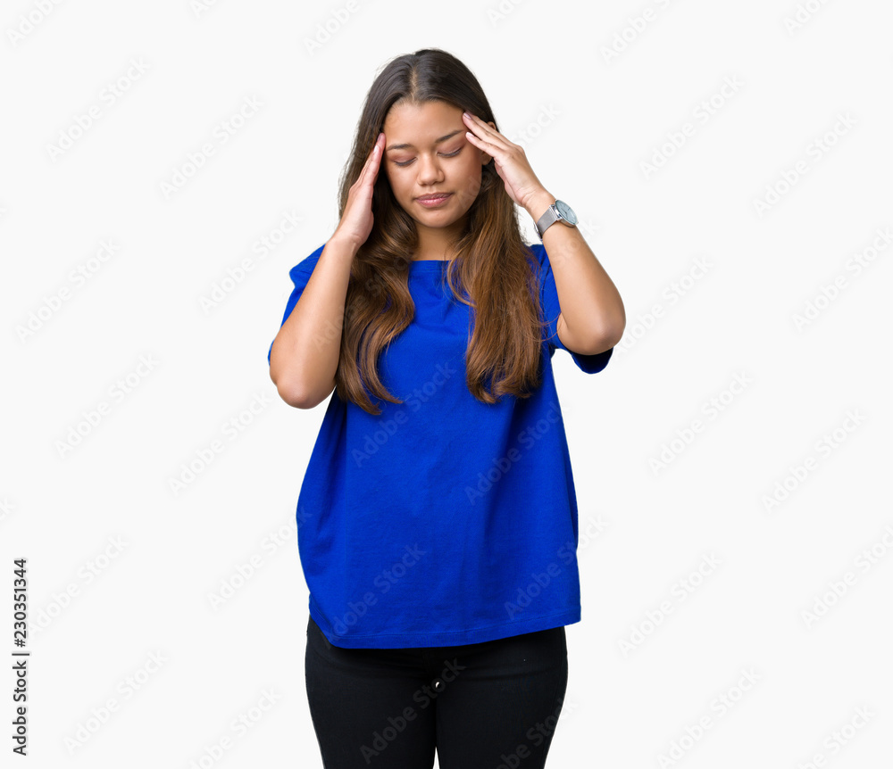 Young beautiful brunette woman wearing blue t-shirt over isolated background with hand on head for pain in head because stress. Suffering migraine. Young beautiful brunette woman wearing blue t-shirt over isolated background with hand on head for pain in head because stress. Suffering migraine.