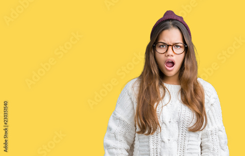 Tableau sur toile Young beautiful brunette hipster woman wearing glasses and winter hat over isola