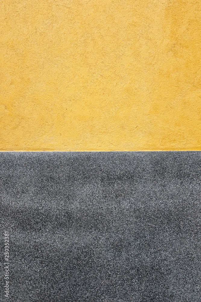 Vertical photo of half yellow fresco wall and gray terrazzo background