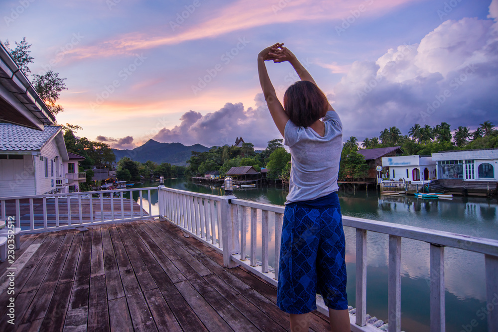 woman practicing yoga at a lake on sunrise