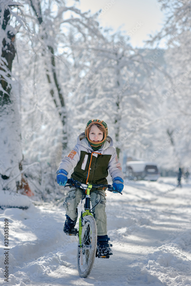 Portrait of happy guy riding bicycle on snowy road