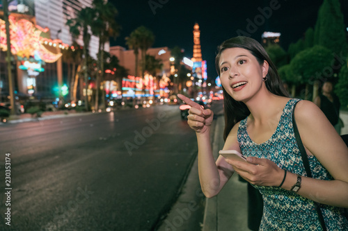 Urban Asian girl using phone walking on street