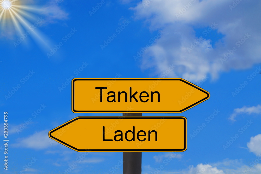 Zwei Schilder weisen auf eine Tankstelle und Ladestation für Elektro Autos Zwei Schilder weisen auf eine Tankstelle und Ladestation für Elektro Autos