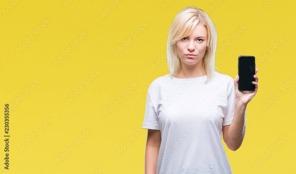 Young beautiful blonde woman showing screen of smartphone over isolated background with a confident expression on smart face thinking serious Young beautiful blonde woman showing screen of smartphone over isolated background with a confident expression on smart face thinking serious