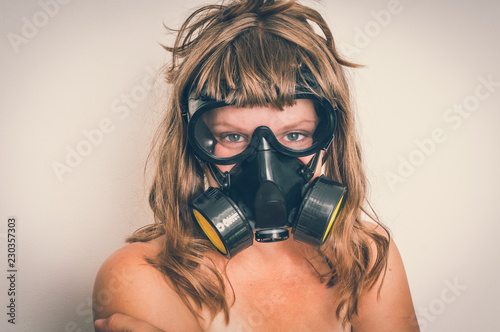 Young naked woman with gas mask
