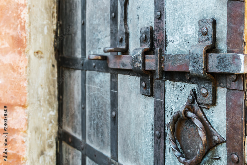 old and rusty latch and handle on metal door. old castle, house, basement or room door