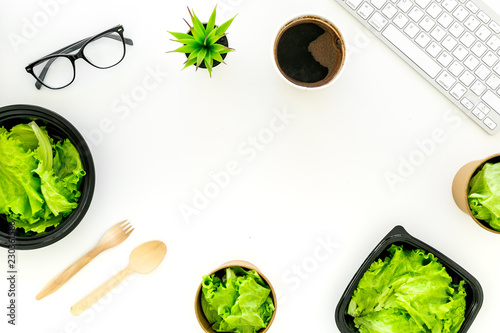 Order healthy food delivery to office. Light, diet meal with lettuce in plastic containers near computer keayboard and glasses on white background top view copy space photo