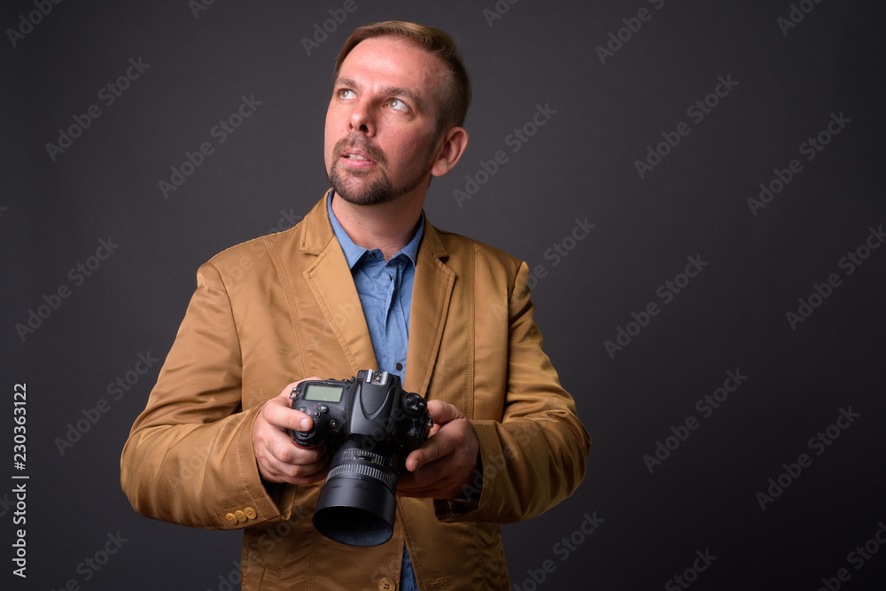 Blond bearded businessman with goatee against gray background Blond bearded businessman with goatee against gray background