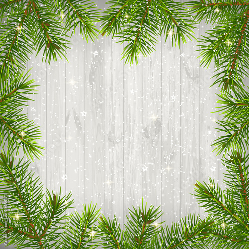 Christmas background with green branches isolated on old white wooden background.
