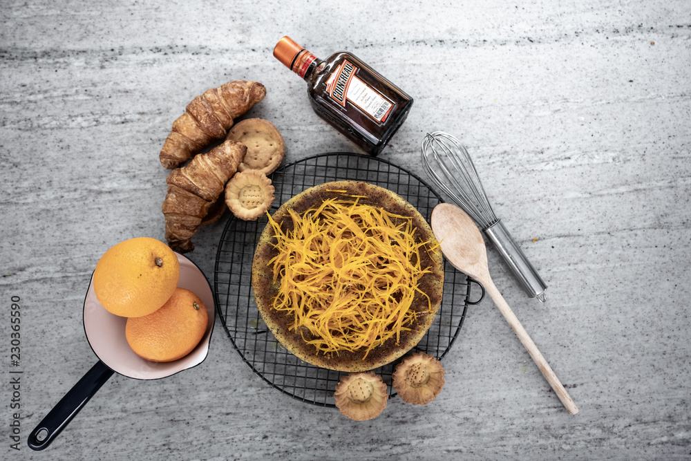 composition of orange and poppy seed cake with croissant and raw material and stainless steel whisk on natural marble top / backgroud baking / baking concept composition of orange and poppy seed cake with croissant and raw material and stainless steel whisk on natural marble top / backgroud baking / baking concept