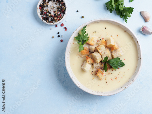cauliflower potato soup puree on blue tabletop, Creamy cauliflower soup with toasted bread croutons. Vegetarian healthy food concept. Ideas and recipes for winter meal. Top view or flat lay.Copy space