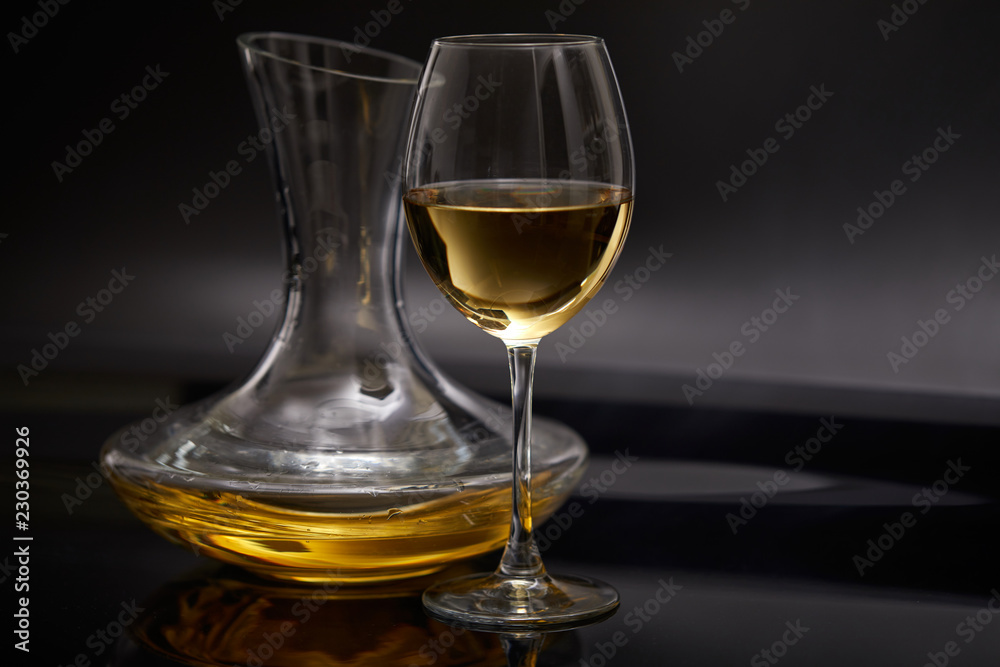 A glass full of wine and wine decanters A glass full of wine and wine decanters