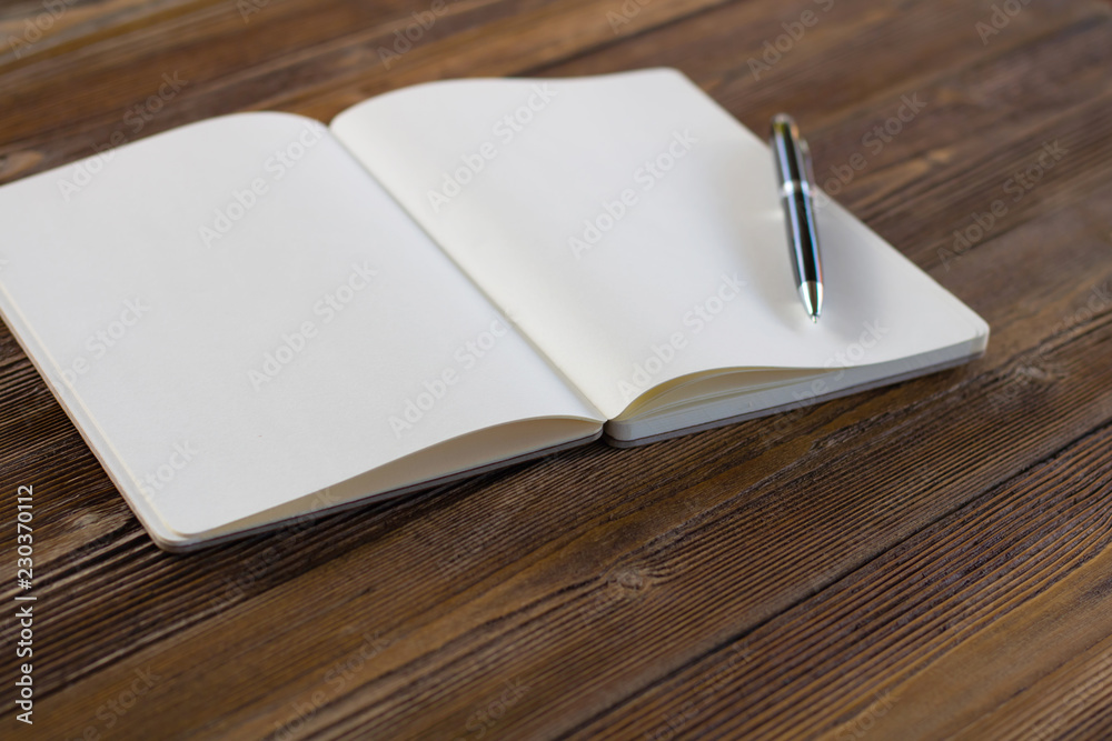 Book and pen open on wood background. Top view.Vintage style. Book and pen open on wood background. Top view.Vintage style.