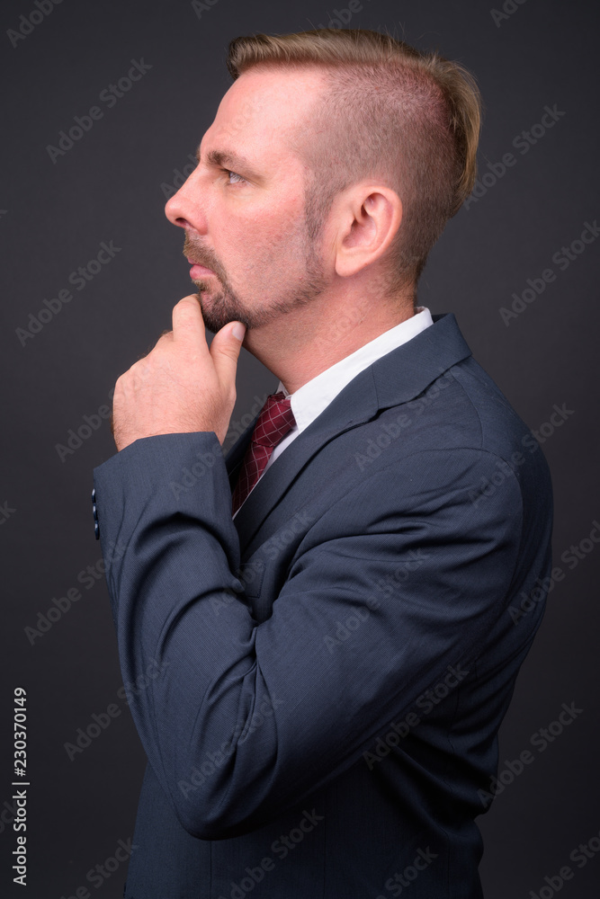 Blond bearded businessman with goatee against gray background Blond bearded businessman with goatee against gray background