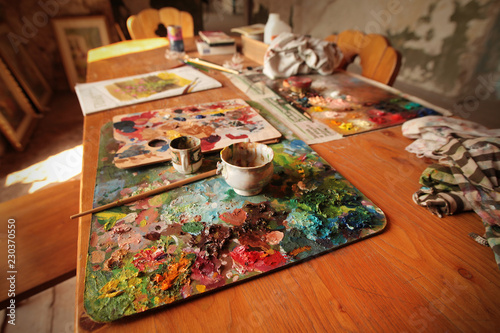 Palette with oil paints on a wooden table