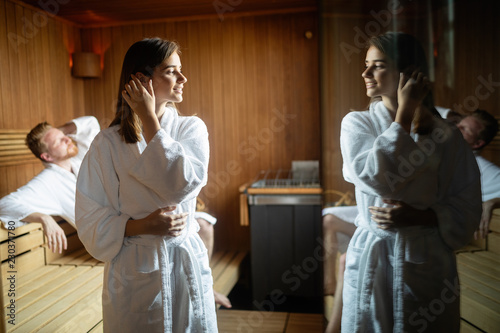 Young happy couple relaxing inside a sauna at spa resort hotel luxury