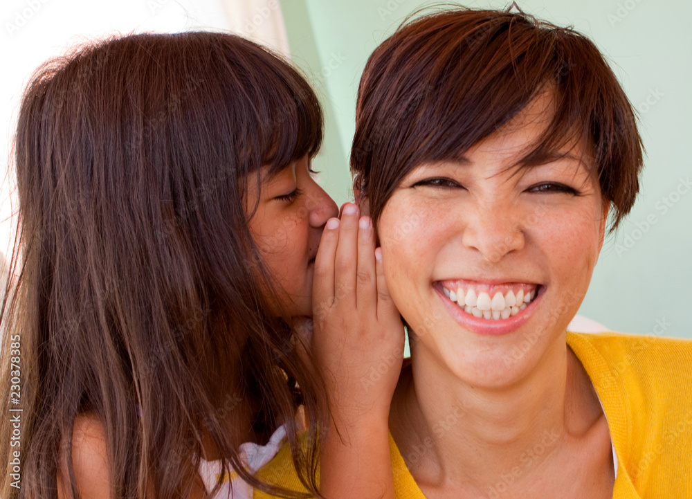 Mother and daughter smiling and telling secrets. Mother and daughter smiling and telling secrets.
