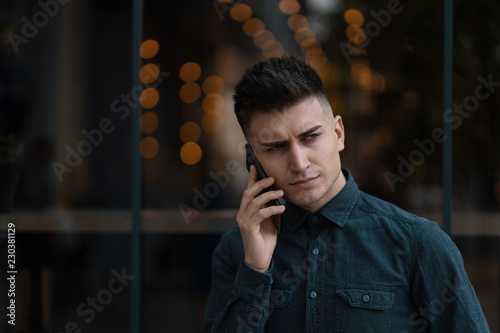 Young confident man talking on the phone.