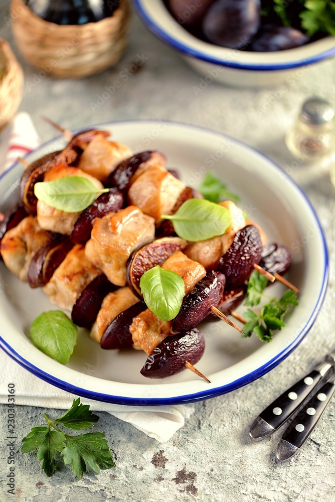 Dietary organic chicken kebab with plums and figs on wooden skewers. Dietary organic chicken kebab with plums and figs on wooden skewers.