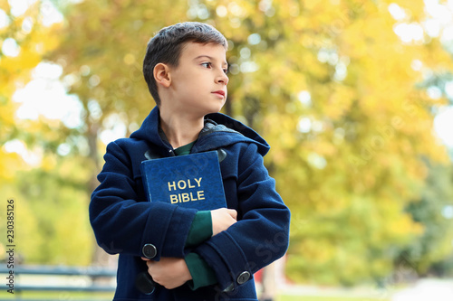 Little boy with Bible in park