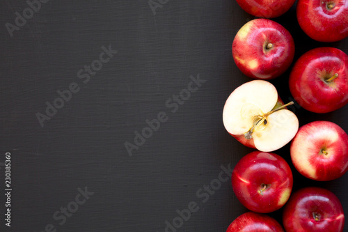 Fresh raw red apples on black background, top view. Flat lay, overhead, from above. Copy space.