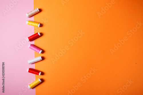 Set of colorful sewing threads on bright background.
