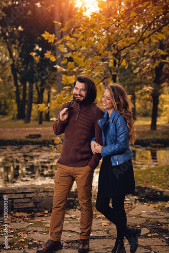 Couple in autumn season colored park enjoying outdoors. © astrosystem
