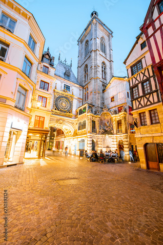 Street view with illuminated buildings and famous clock tower during the twilight in the old town of Rouen city in France