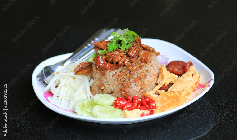 Fried rice mixed Shrimp paste with pork and fried egg in plate on black table. Thai food (Kao Cluk Ka Pi). - obrazy, fototapety, plakaty 