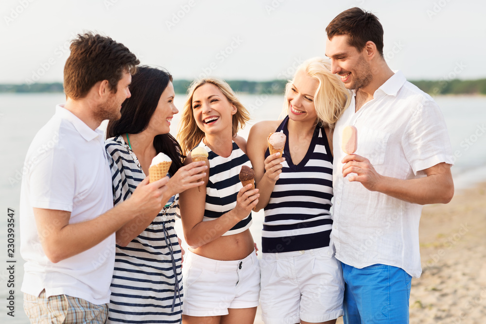 friendship, leisure and people concept - group of happy friends in striped clothes eating ice cream on beach friendship, leisure and people concept - group of happy friends in striped clothes eating ice cream on beach