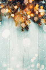 Christmas fir branches with lights on wooden planks