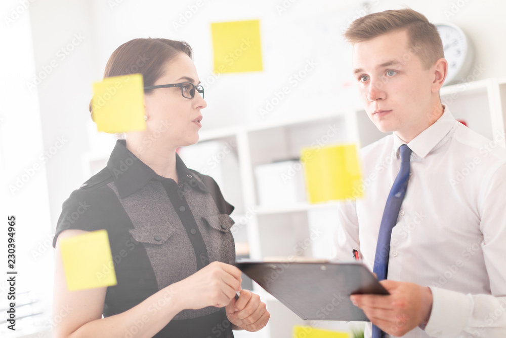 Young people are discussing in the office near the Board with stickers. Young people are discussing in the office near the Board with stickers.