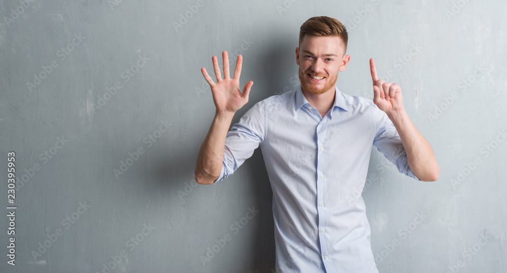 Young redhead business man over grey grunge wall showing and pointing up with fingers number six while smiling confident and happy. Young redhead business man over grey grunge wall showing and pointing up with fingers number six while smiling confident and happy.