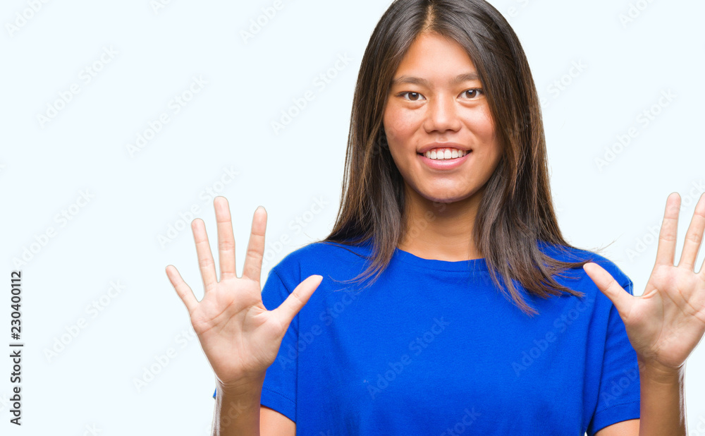 Young asian woman over isolated background showing and pointing up with fingers number ten while smiling confident and happy.