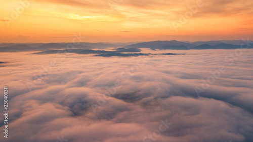 Foggy dawn in mountains. Sea of fog between mountain peaks