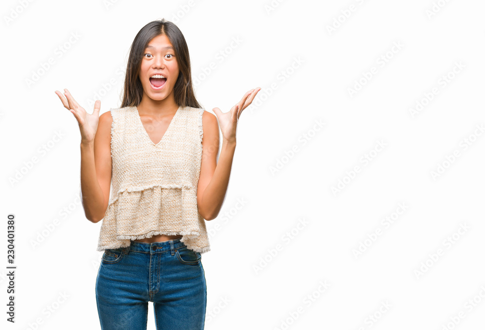 Young asian woman over isolated background celebrating crazy and amazed for success with arms raised and open eyes screaming excited. Winner concept Young asian woman over isolated background celebrating crazy and amazed for success with arms raised and open eyes screaming excited. Winner concept
