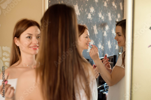 portrait of woman doing maquillage to her sister