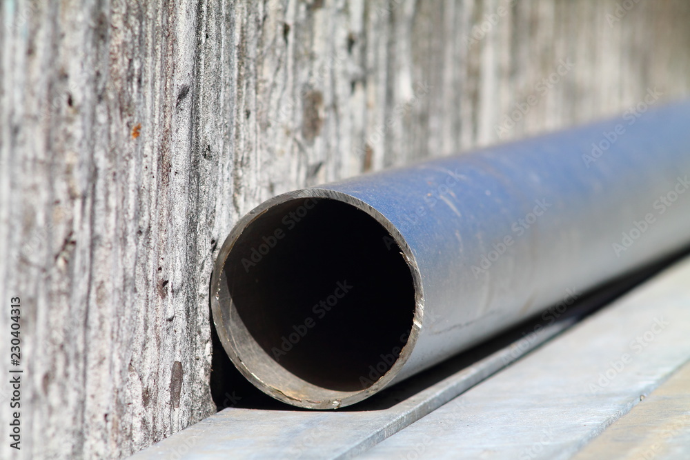 Hole metal pipe on construction area against concrete wall. Hole metal pipe on construction area against concrete wall.