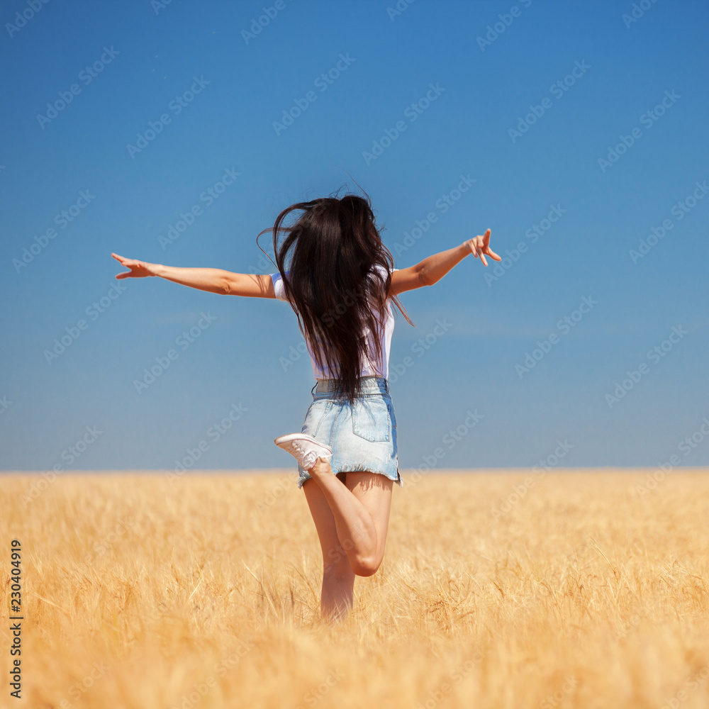 Happy woman enjoying the life in the field Nature beauty, blue cloudy sky and colorful field with golden wheat. Outdoor lifestyle. Freedom concept. Woman jump in summer field Happy woman enjoying the life in the field Nature beauty, blue cloudy sky and colorful field with golden wheat. Outdoor lifestyle. Freedom concept. Woman jump in summer field