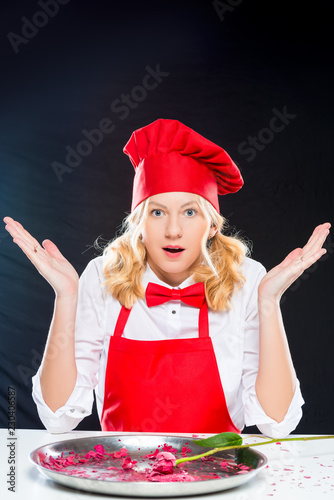 Emotional chef with a frozen and broken rose on a black background, experiments with liquid nitrogen photo