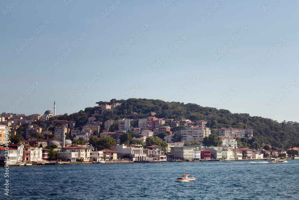 View of a small, wooden fishing boat on Bosphorus and the Asian side of Istanbul.