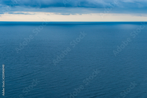 Blue sea water, view of the horizon and clouds, laconic seascape