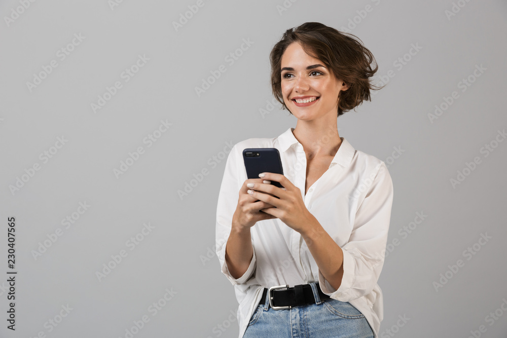Happy young business woman posing using mobile phone chatting. Happy young business woman posing using mobile phone chatting.