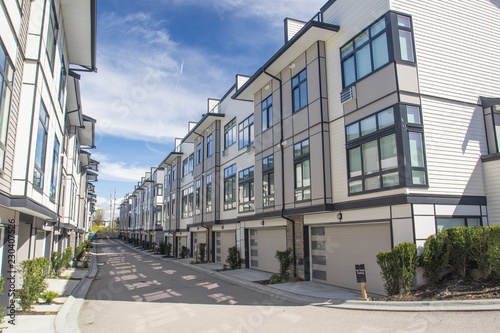 Nice development of new townhouses. External facade of a row of colorful modern urban townhouses.brand new houses just after construction on real estate market