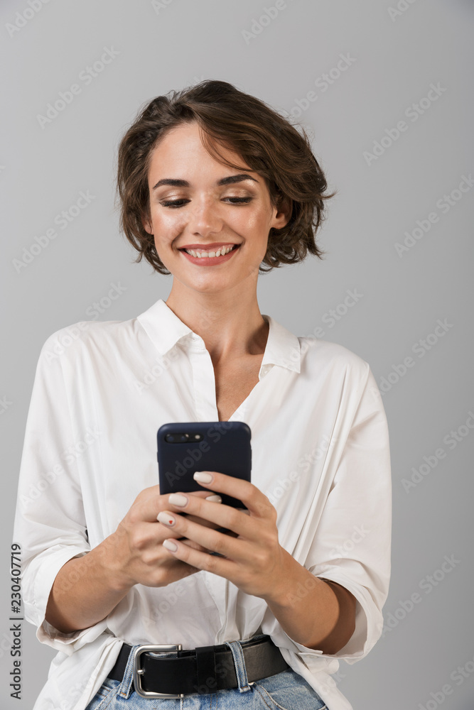 Happy young business woman posing using mobile phone chatting. Happy young business woman posing using mobile phone chatting.