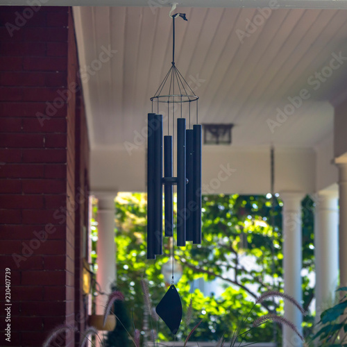 Canvas Print Wind chime on a red brick house with white pillars