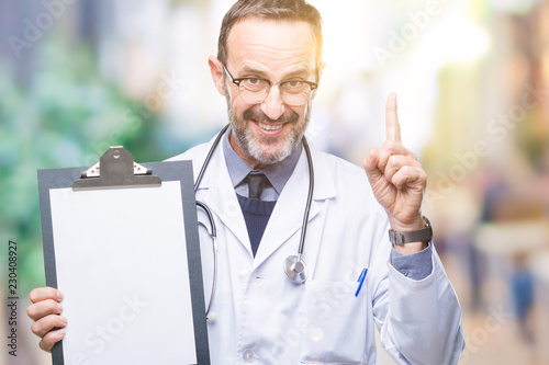 Middle age senior hoary doctor man holding clipboard isolated background surprised with an idea or question pointing finger with happy face, number one