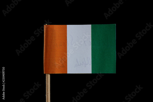 A official flag of Ivory Coast on toothpick and on black background. The Ivory Coast is located in west africa. photo