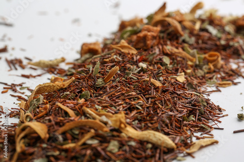 Still life, aromatic dry tea with fruits and petals, close up on white background