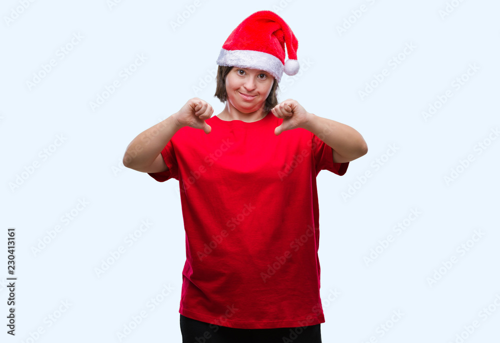 Young adult woman with down syndrome wearing christmas hat over isolated background looking confident with smile on face, pointing oneself with fingers proud and happy. Young adult woman with down syndrome wearing christmas hat over isolated background looking confident with smile on face, pointing oneself with fingers proud and happy.